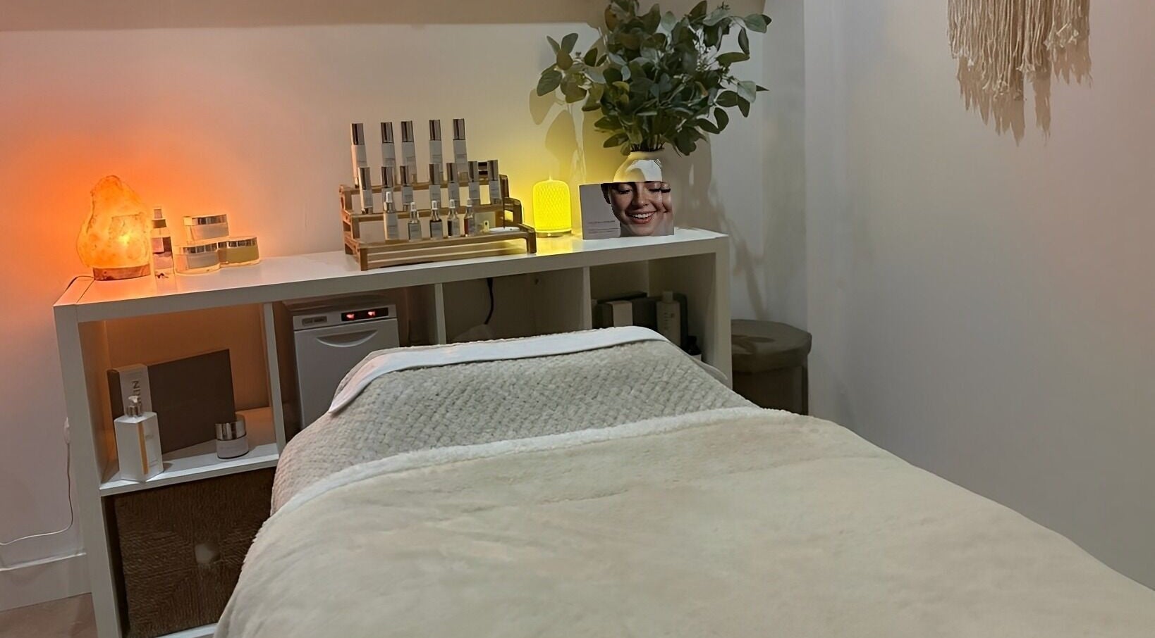 Cozy spa treatment room at Harringtons Devizes, GB with warm lighting and skincare products.