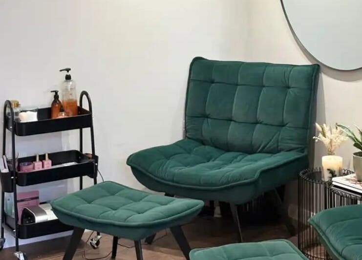 Comfortable seating area at Harringtons Devizes, Devizes, GB with green chairs and small side table.