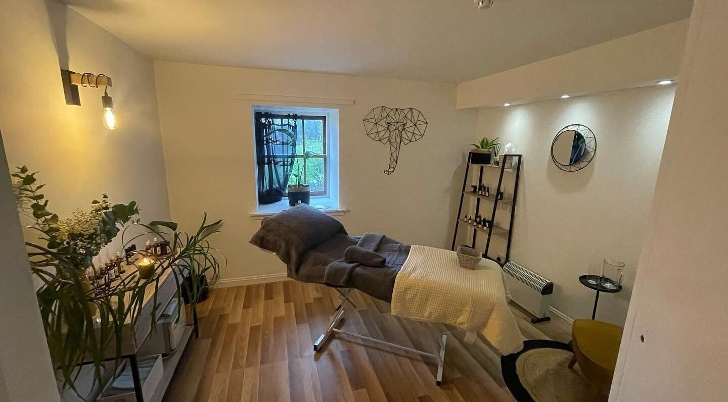 Tranquil massage room at The Wellness Lounge with Oils in Bloom, East Lothian, Scotland, GB. Soft lighting and decor.