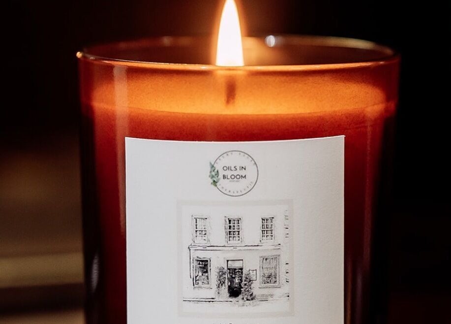 A glowing candle at The Wellness Lounge with Oils in Bloom, East Lothian, Scotland, GB offers a tranquil ambiance.