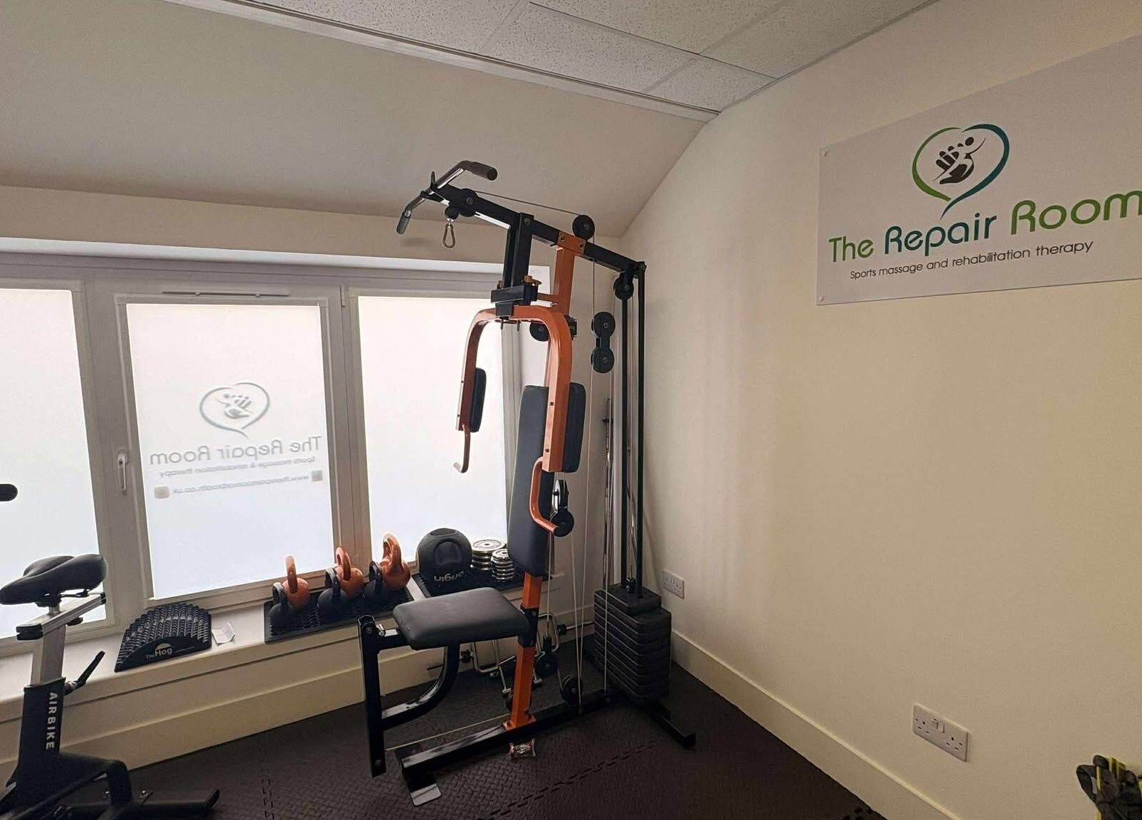 The Repair Room's gym area in Arbroath, Scotland, GB showcases fitness equipment and a branded sign.