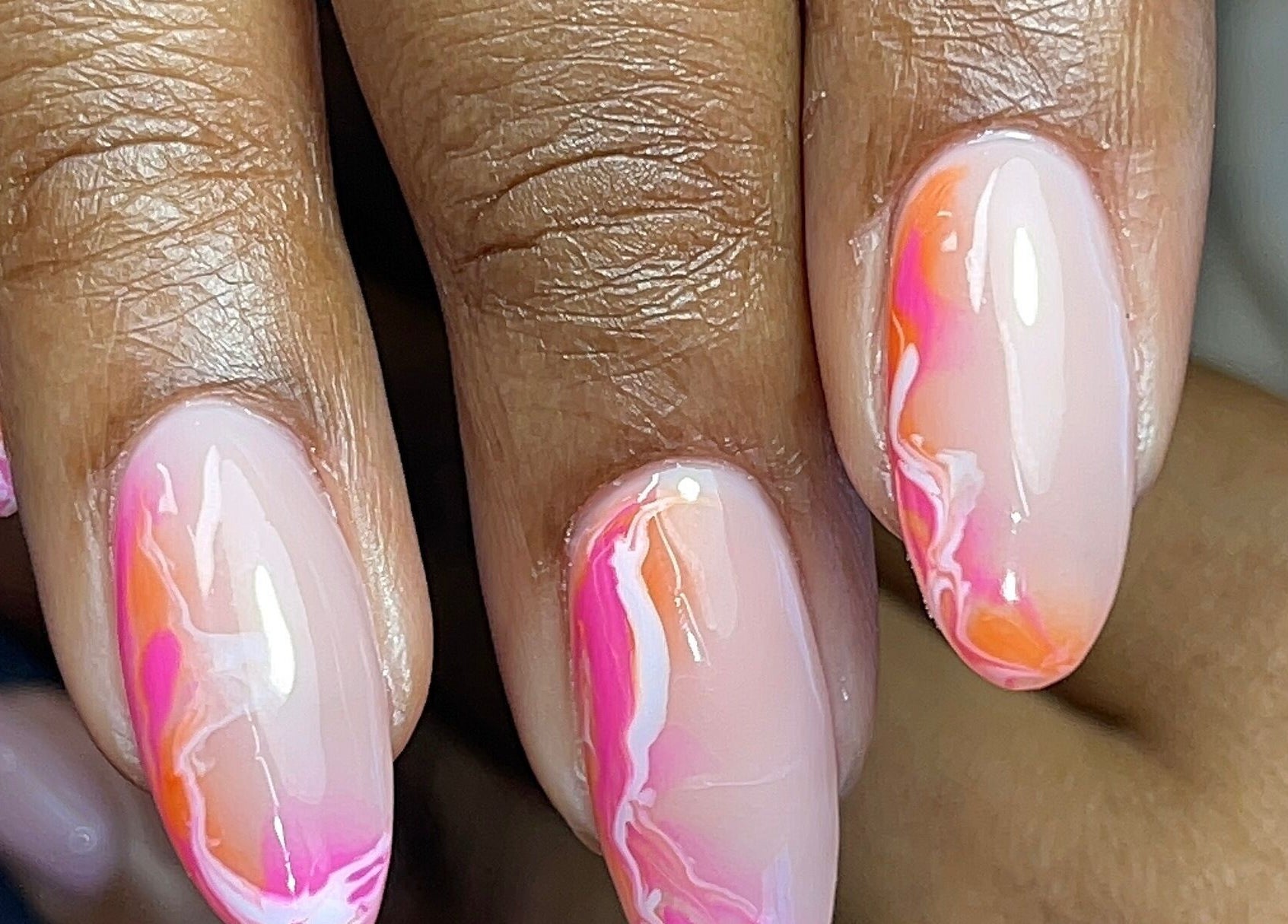 Vibrant pink and orange swirl nails at GelJunkiess & Co., Portmore, JM showcasing artistry and style.