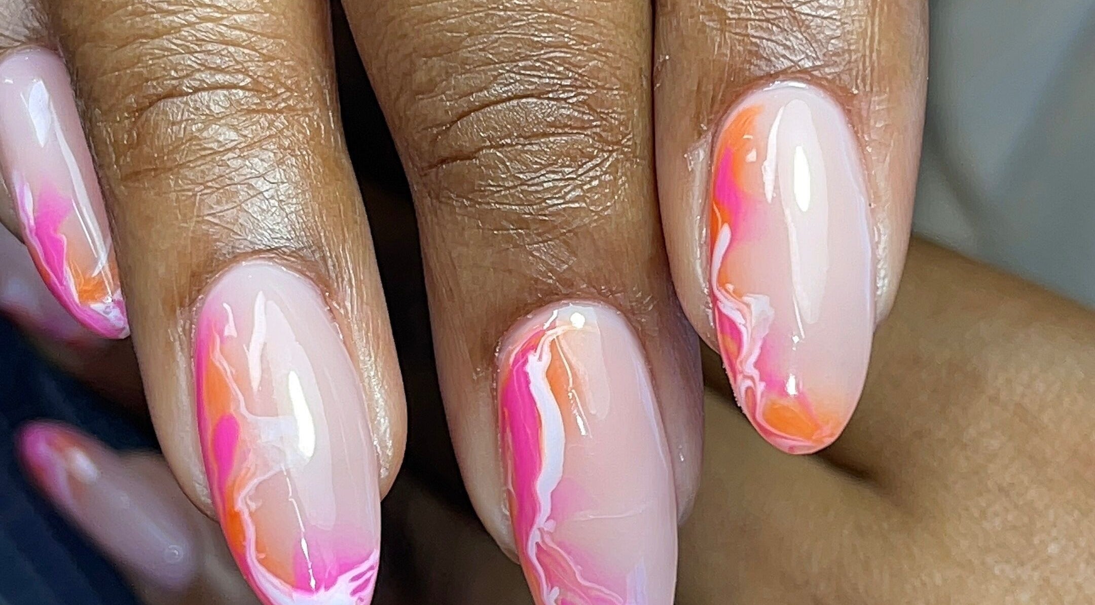 Vibrant pink and orange swirl nails at GelJunkiess & Co., Portmore, JM showcasing artistry and style.