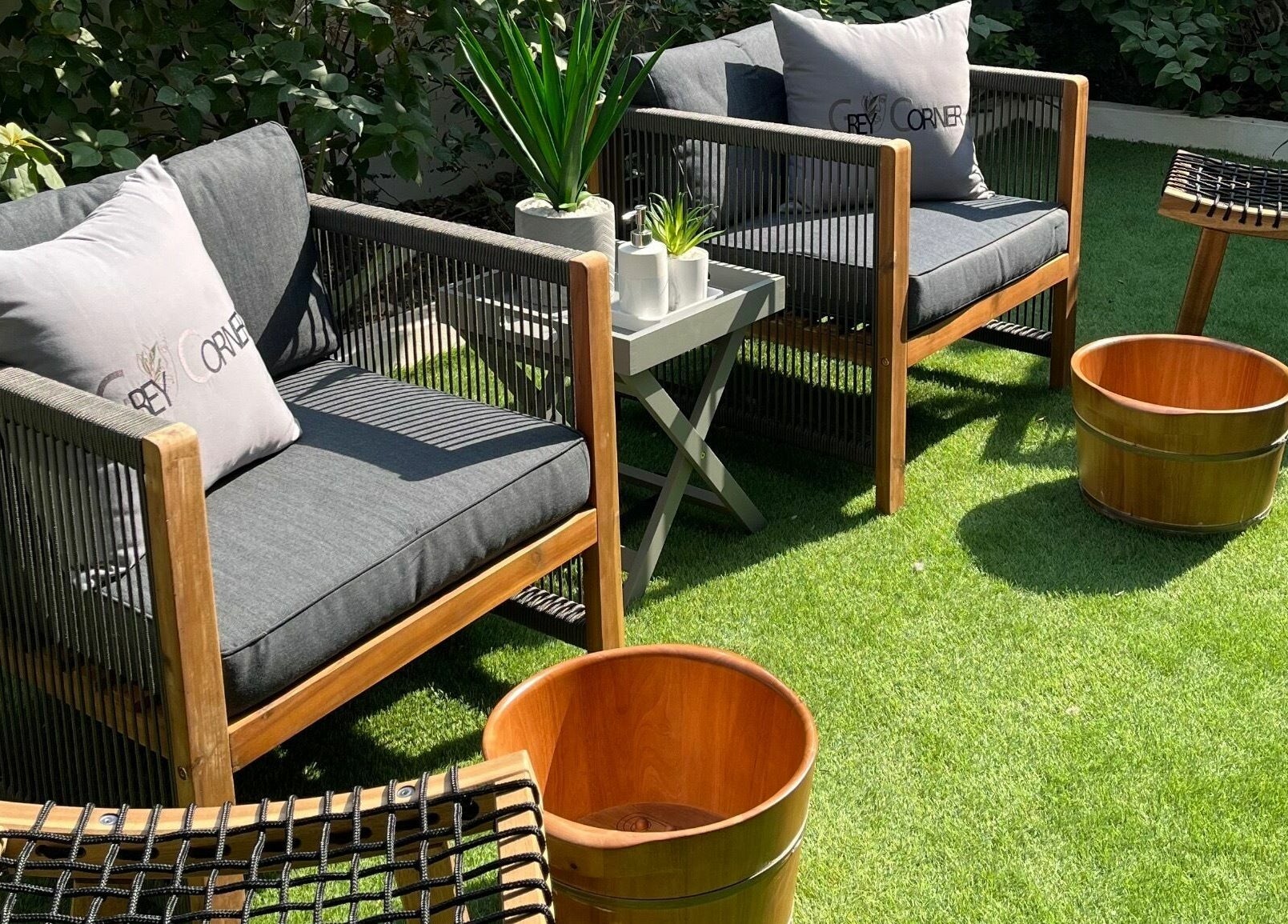 Relaxing outdoor seating at Grey Corner Salon, Al Mubarraz, Eastern Province, SA, with lush greenery.