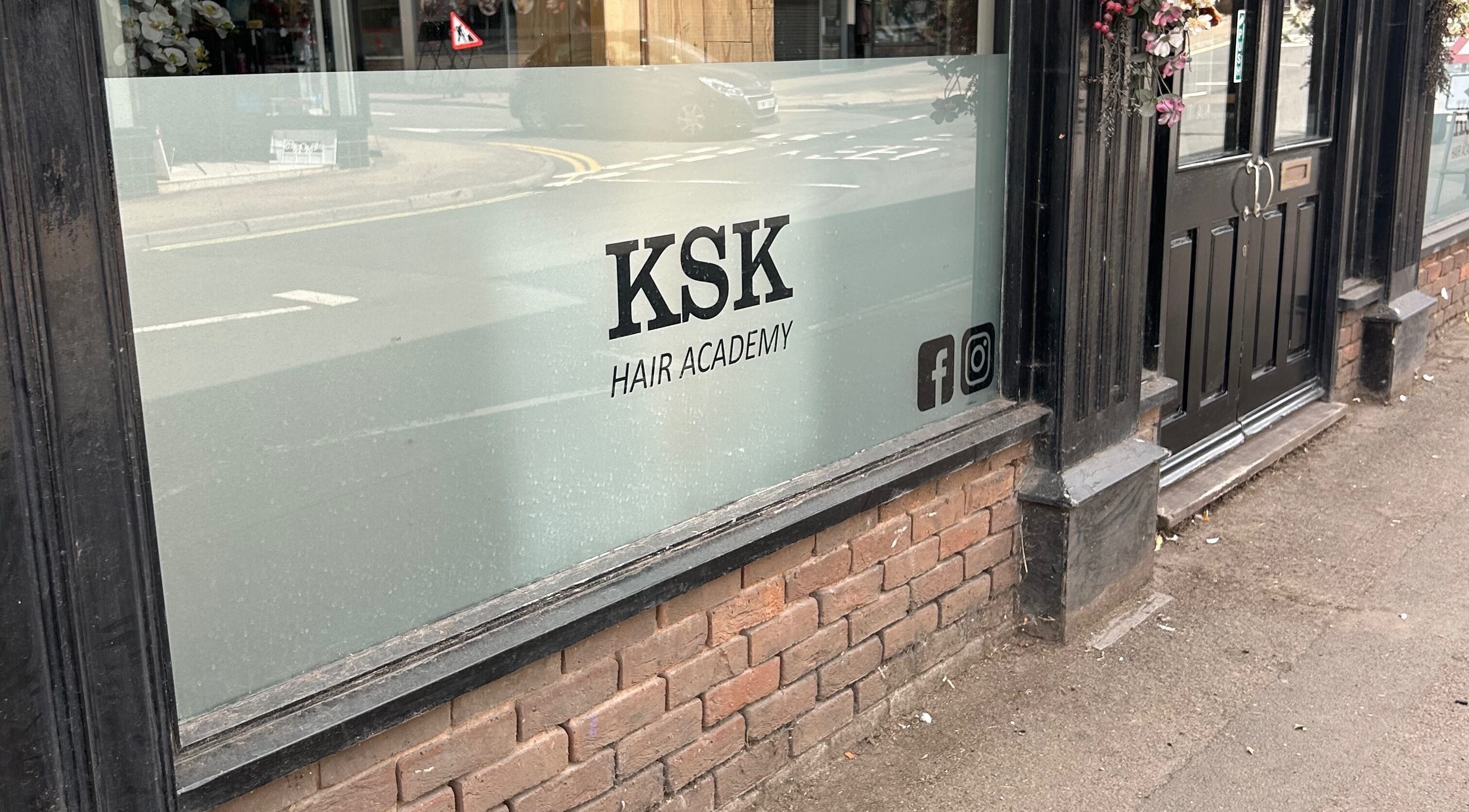 Exterior view of Ksk Hair Academy, Lydney, England, showing the entrance and signage on the window.