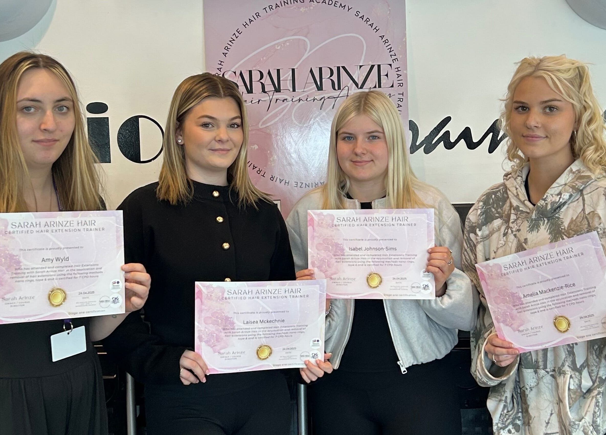 Graduates hold certificates at Ksk Hair Academy in Lydney, England, showcasing their hair skills.