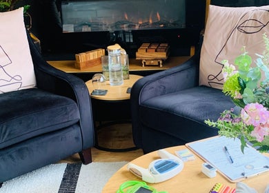 Cozy seating with floral accents at Pure Calma, Bournemouth, England, GB. Ideal for relaxation and wellness.