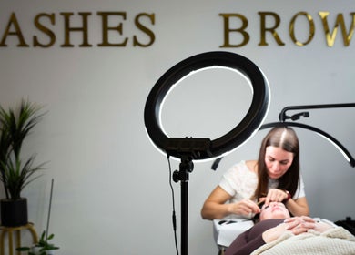 Lash artist at Belle Beauty Studio & Academy, Gravesend, England, GB, applying extensions under professional lighting.