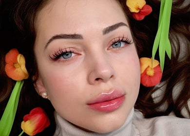 Close-up of a woman's face adorned with flowers at Belle Beauty Studio & Academy, Gravesend, England, GB.