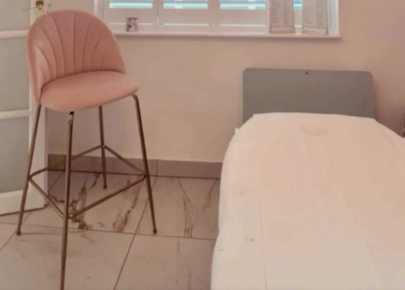 Peaceful treatment room at The Salon by Jasmine, West Haddon, England, GB featuring a plush chair and bed.