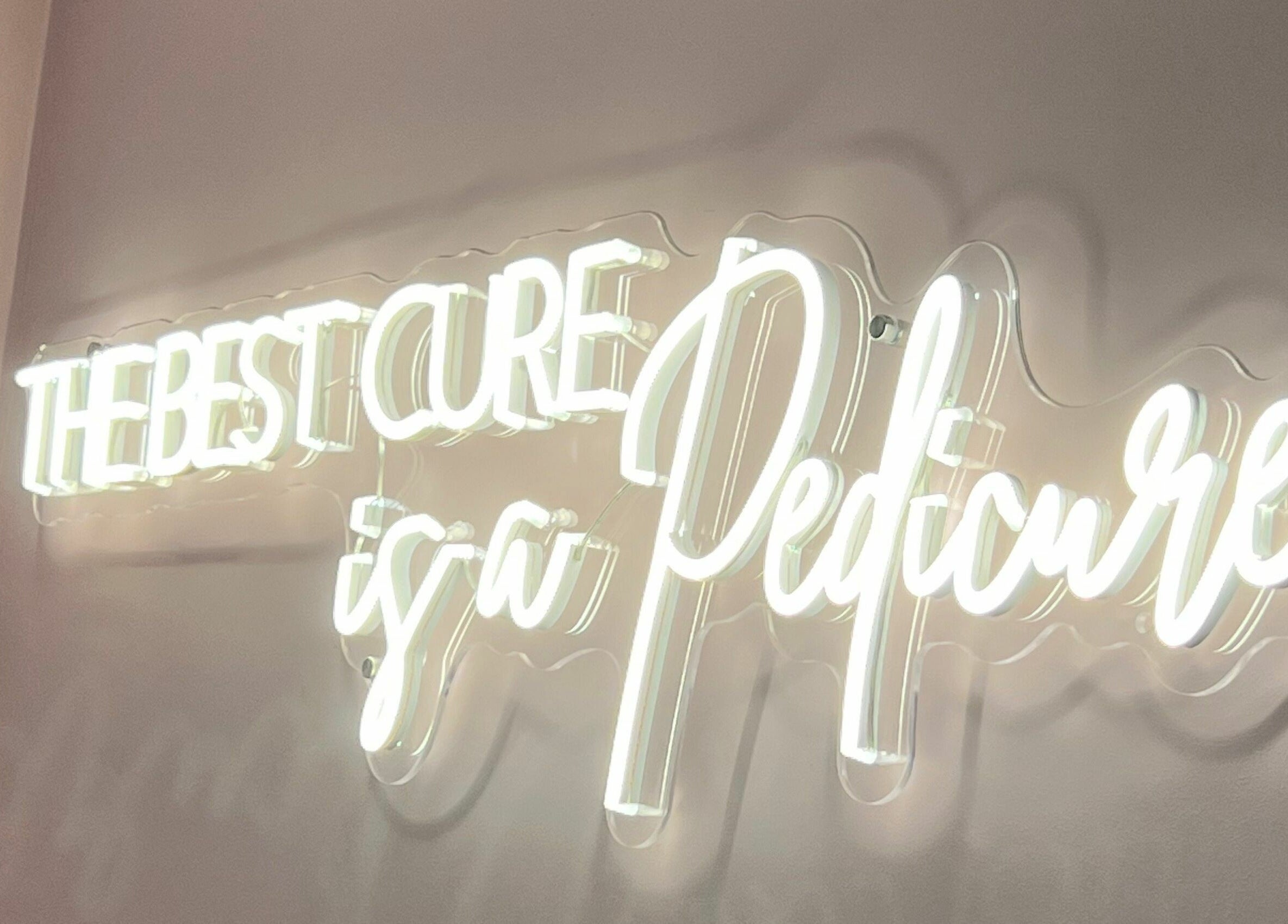 Neon sign 'The best cure is a pedicure' at The Salon by Jasmine, West Haddon, England, GB.