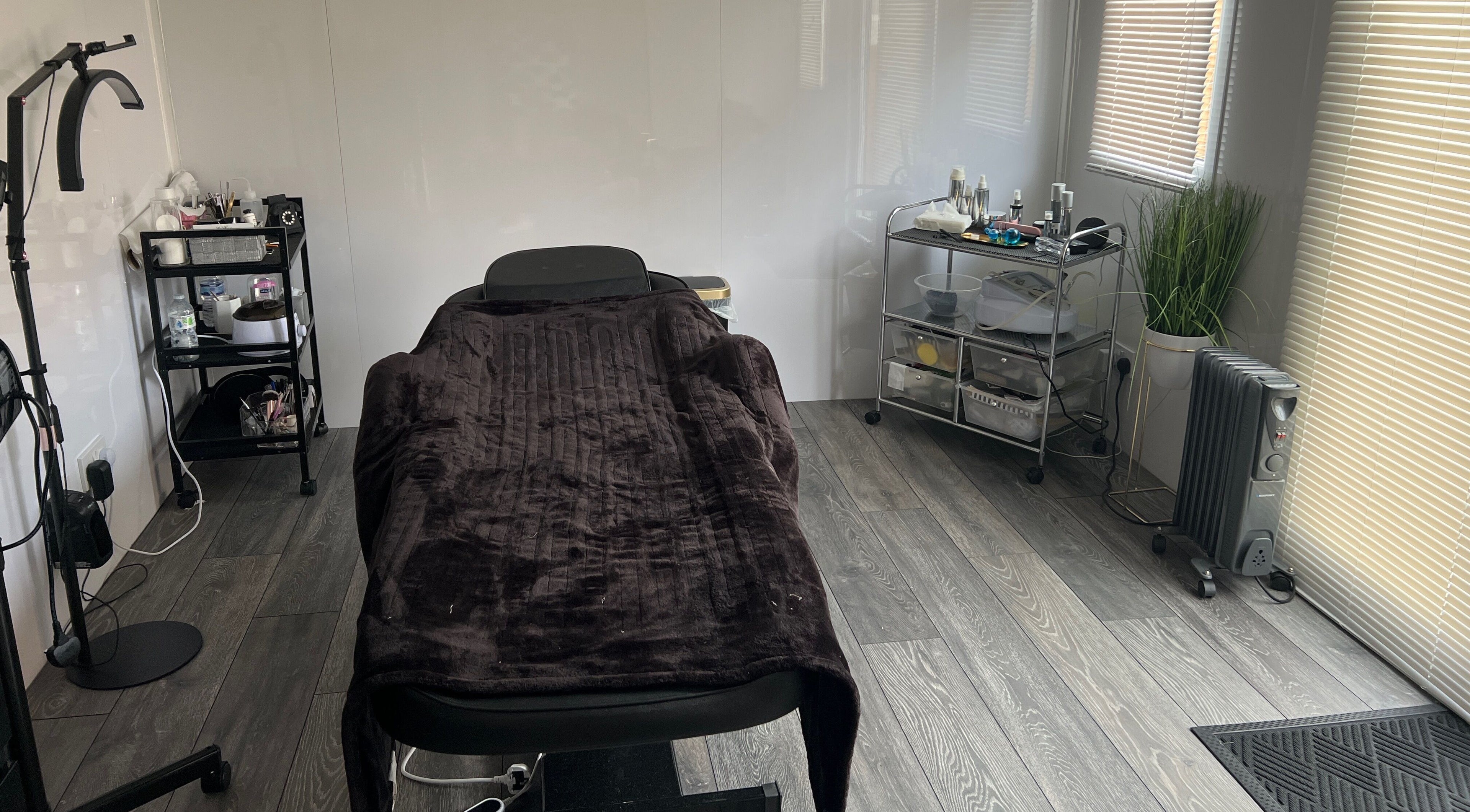 Beauty by JM's serene treatment room in Telford, England with a massage bed and modern decor.