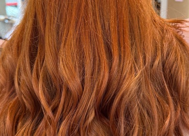 Vibrant red hair styled in soft waves at Bonito Hair and Beauty, Rushden, England, GB.