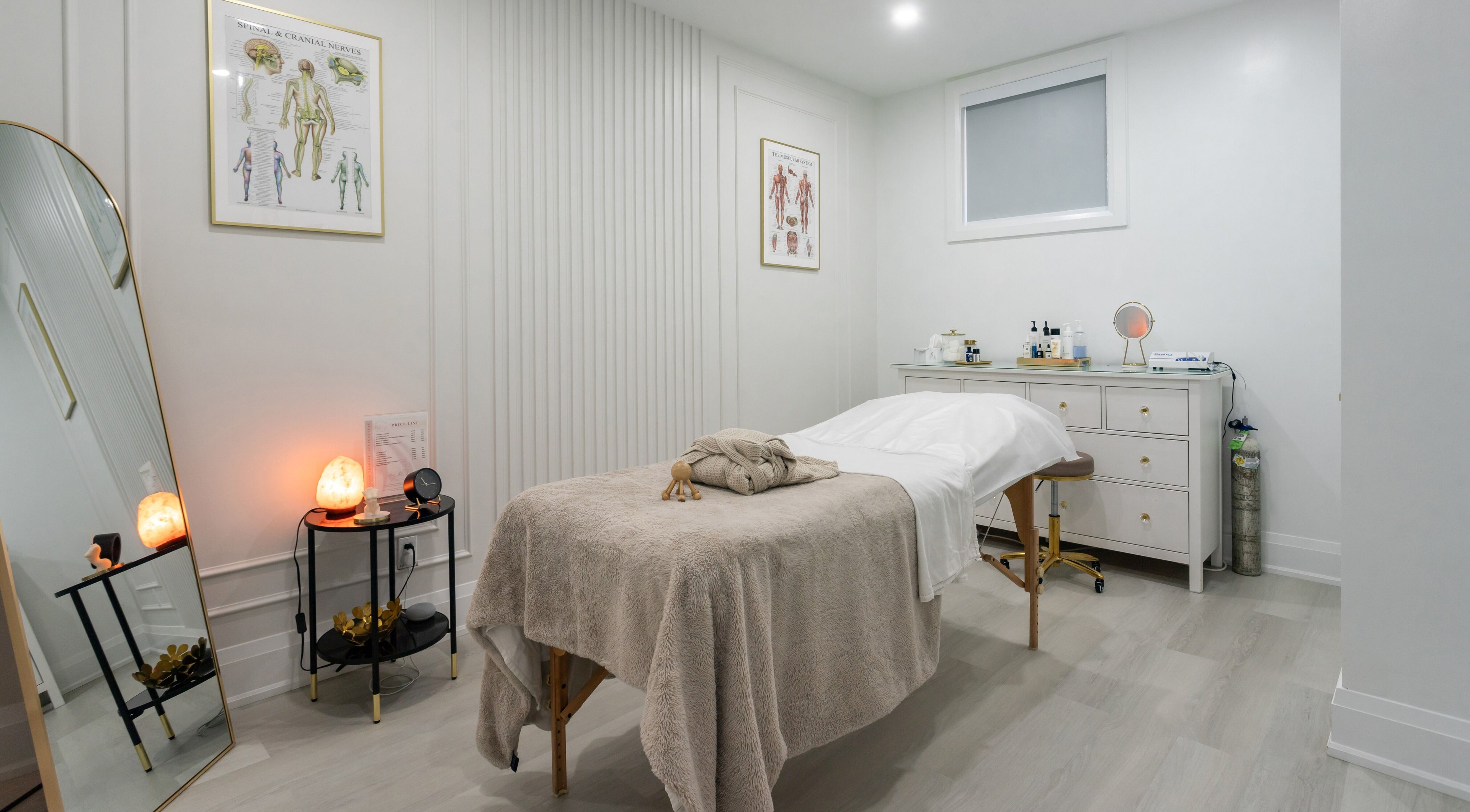 Serene spa treatment room at Aura Wellness in Vaughan, Ontario, CA with massage table and calming decor.