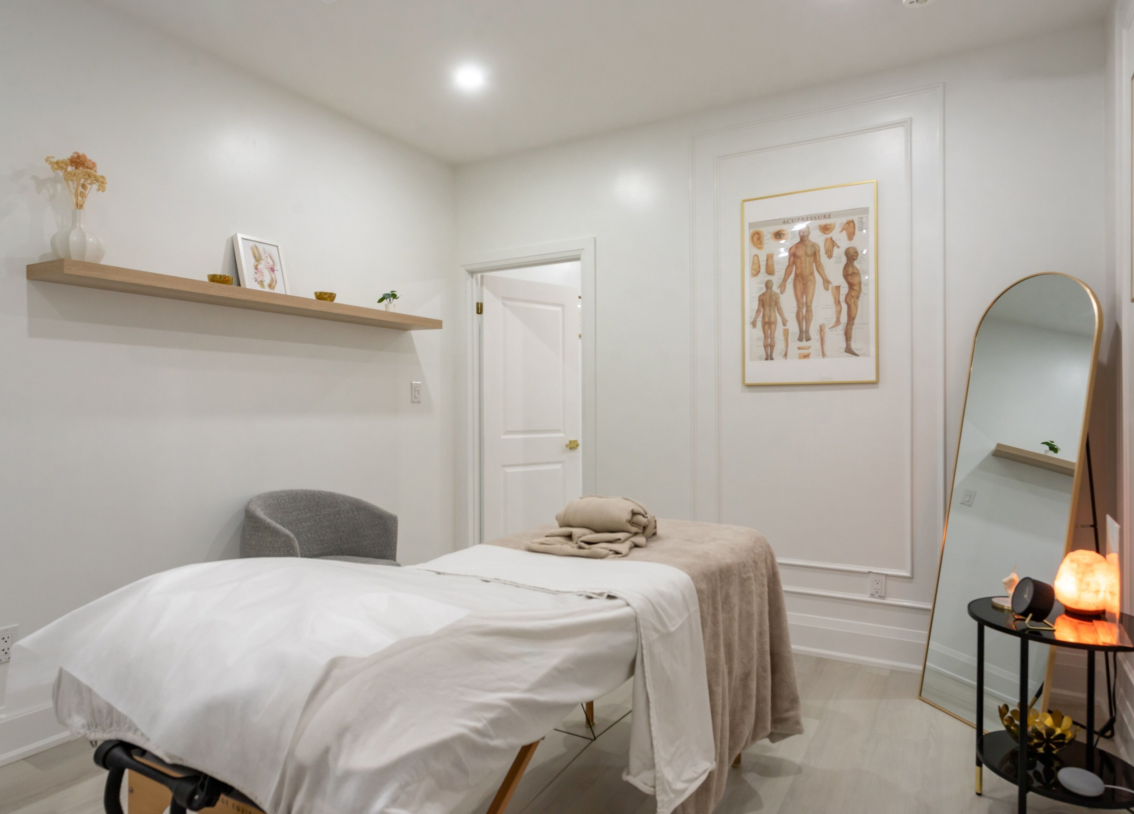 Calming massage room at Aura Wellness, Vaughan, Ontario, CA, featuring a massage table and peaceful decor.