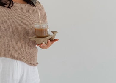 Guest at ILash and Beauty Bar in Baringa, Queensland, AU holding a coffee in cozy attire.