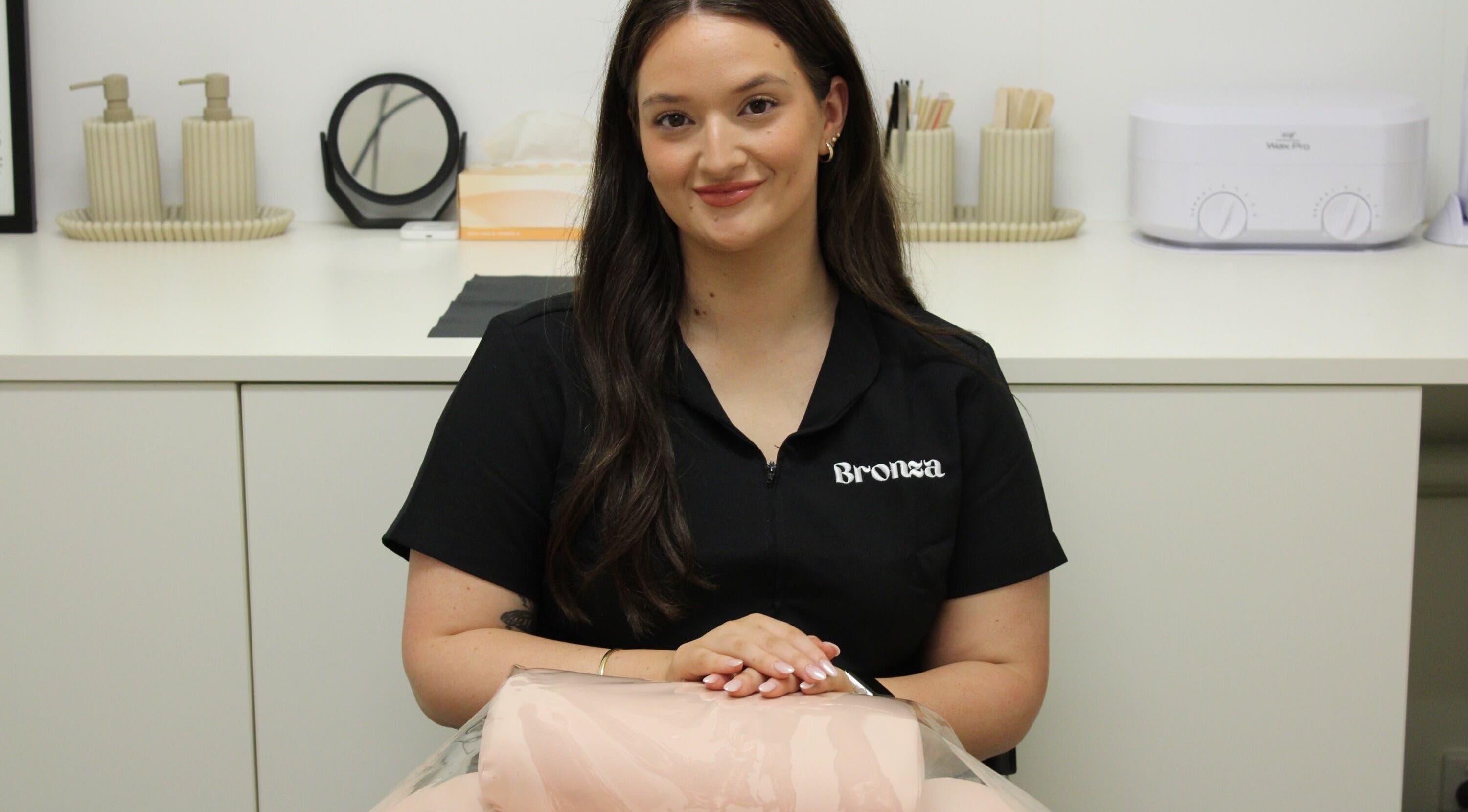 Bronza staff member in a chic interior, Warrnambool, Victoria, AU, embodying relaxation and professionalism.