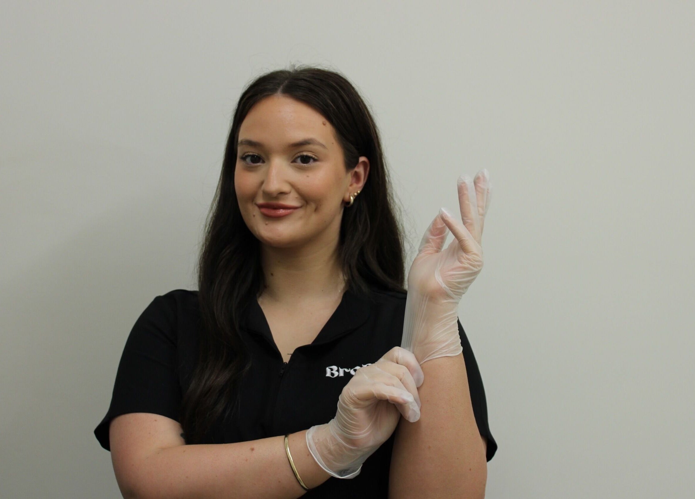Smiling beauty therapist at Bronza, Warrnambool, Victoria, AU, wearing gloves and ready for a treatment session.