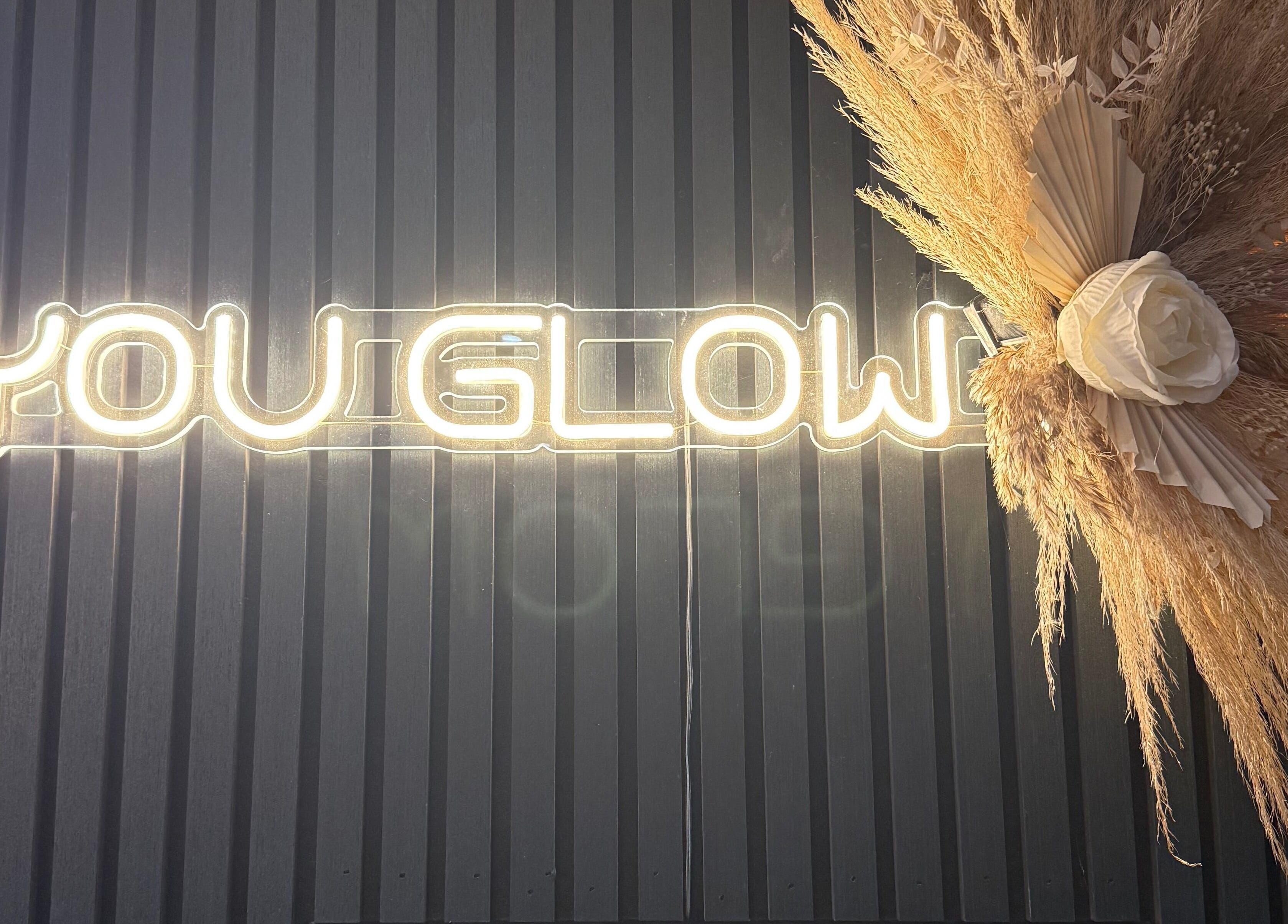Neon 'You Glow' sign with floral decor at The Glam Bar in Auchterarder, Scotland, GB.