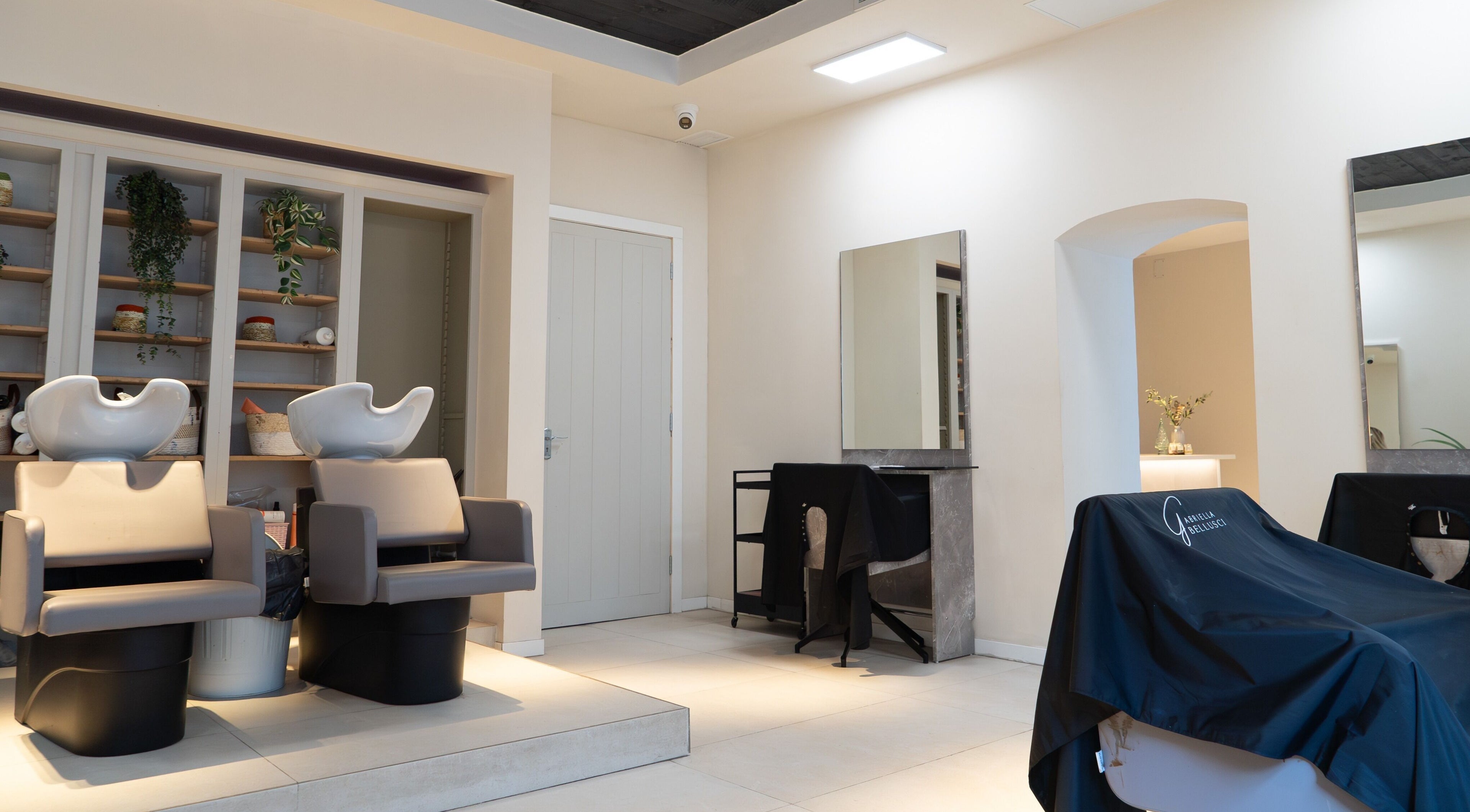 Chic salon interior at The Collective Hair & Beauty, Gibraltar, GI with modern styling stations and decor.