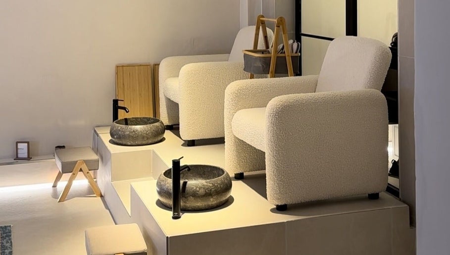 Modern pedicure seating area at SKiN At The Collective in Gibraltar, GI with plush chairs and stone basins.