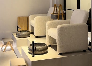 Modern pedicure seating area at SKiN At The Collective in Gibraltar, GI with plush chairs and stone basins.