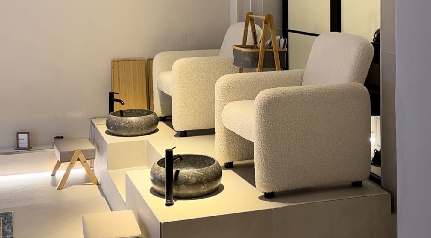Modern pedicure seating area at SKiN At The Collective in Gibraltar, GI with plush chairs and stone basins.