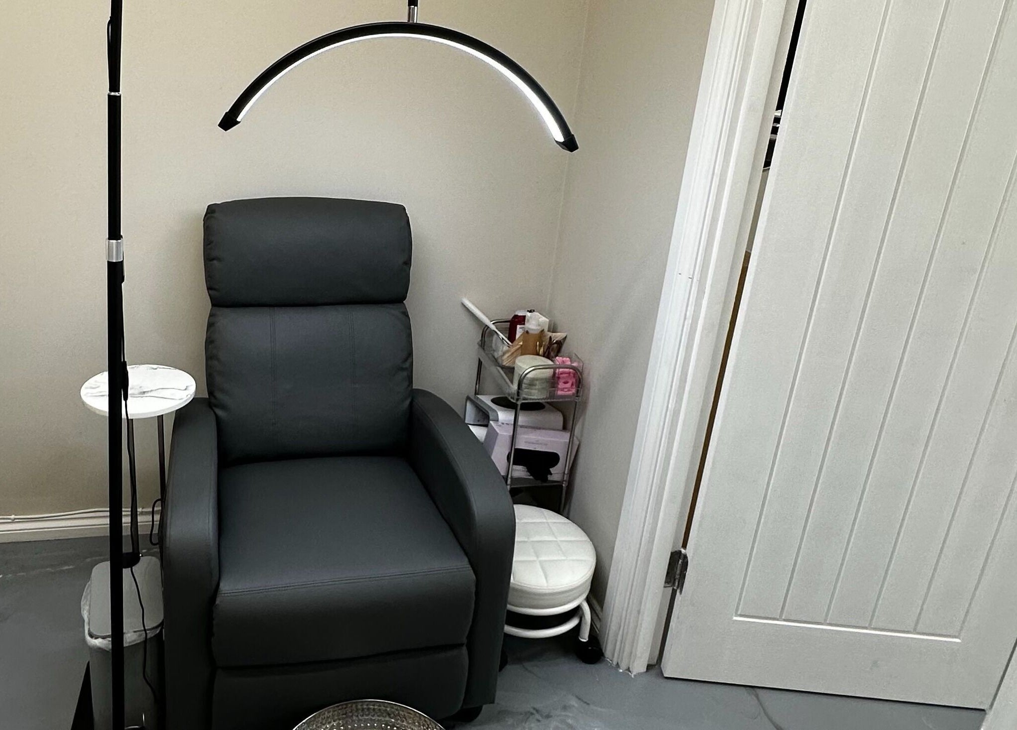 Comfortable seating area at Polished By Sam, Bracknell, England, GB, featuring a sleek black chair and modern lighting.