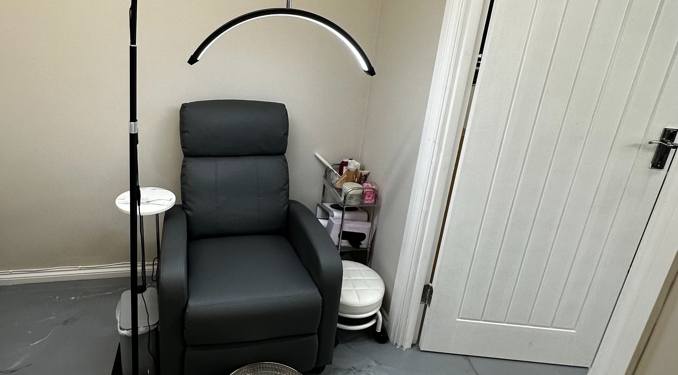 Comfortable seating area at Polished By Sam, Bracknell, England, GB, featuring a sleek black chair and modern lighting.