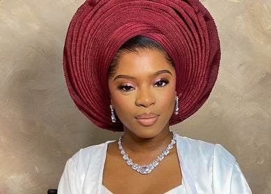 Woman wearing a red traditional headpiece and jewelry at Belleyenn Artistry, Lagos, Lagos, NG.