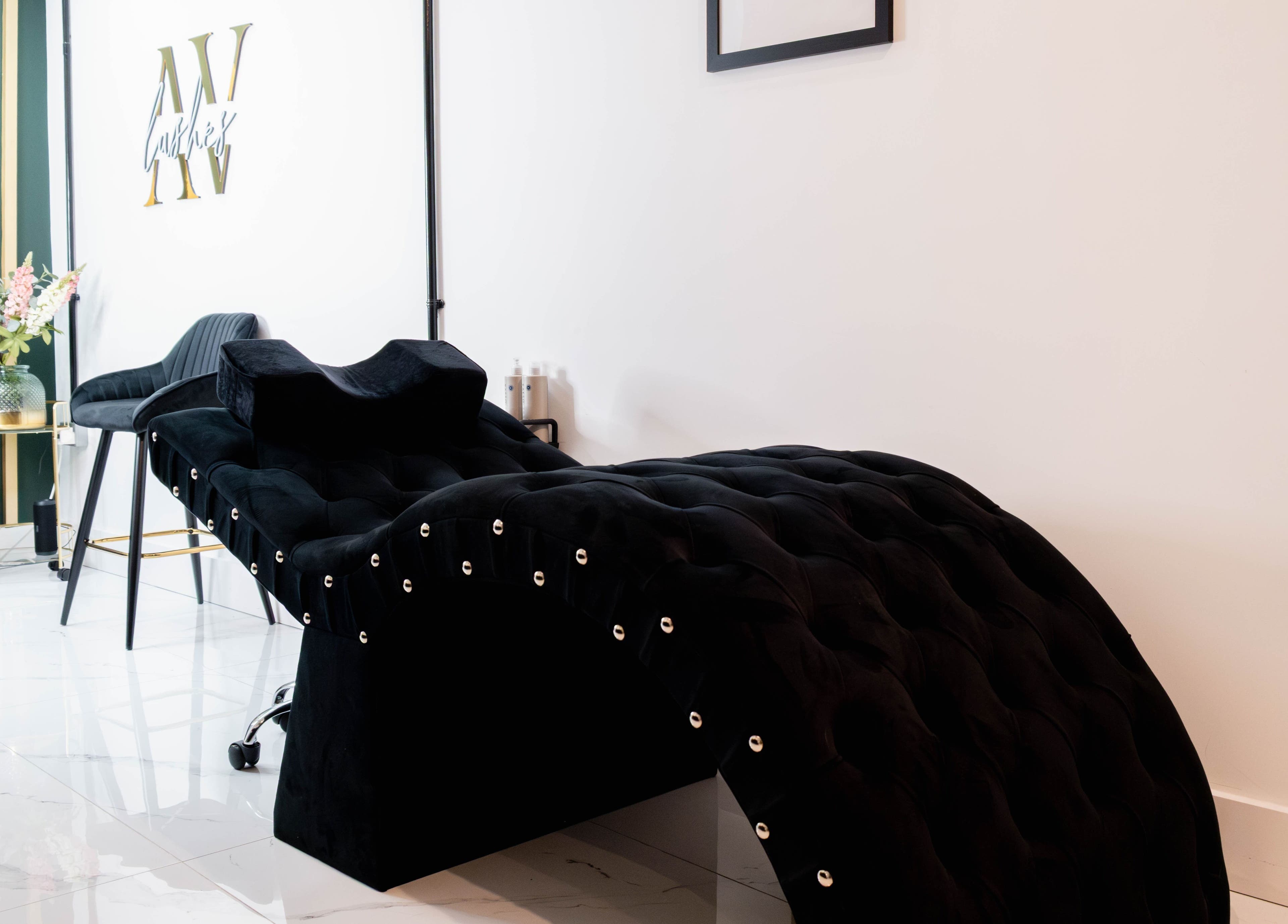 Luxurious lounge at AV Lashes London, London, England, GB with plush decor and sleek black styling chair.