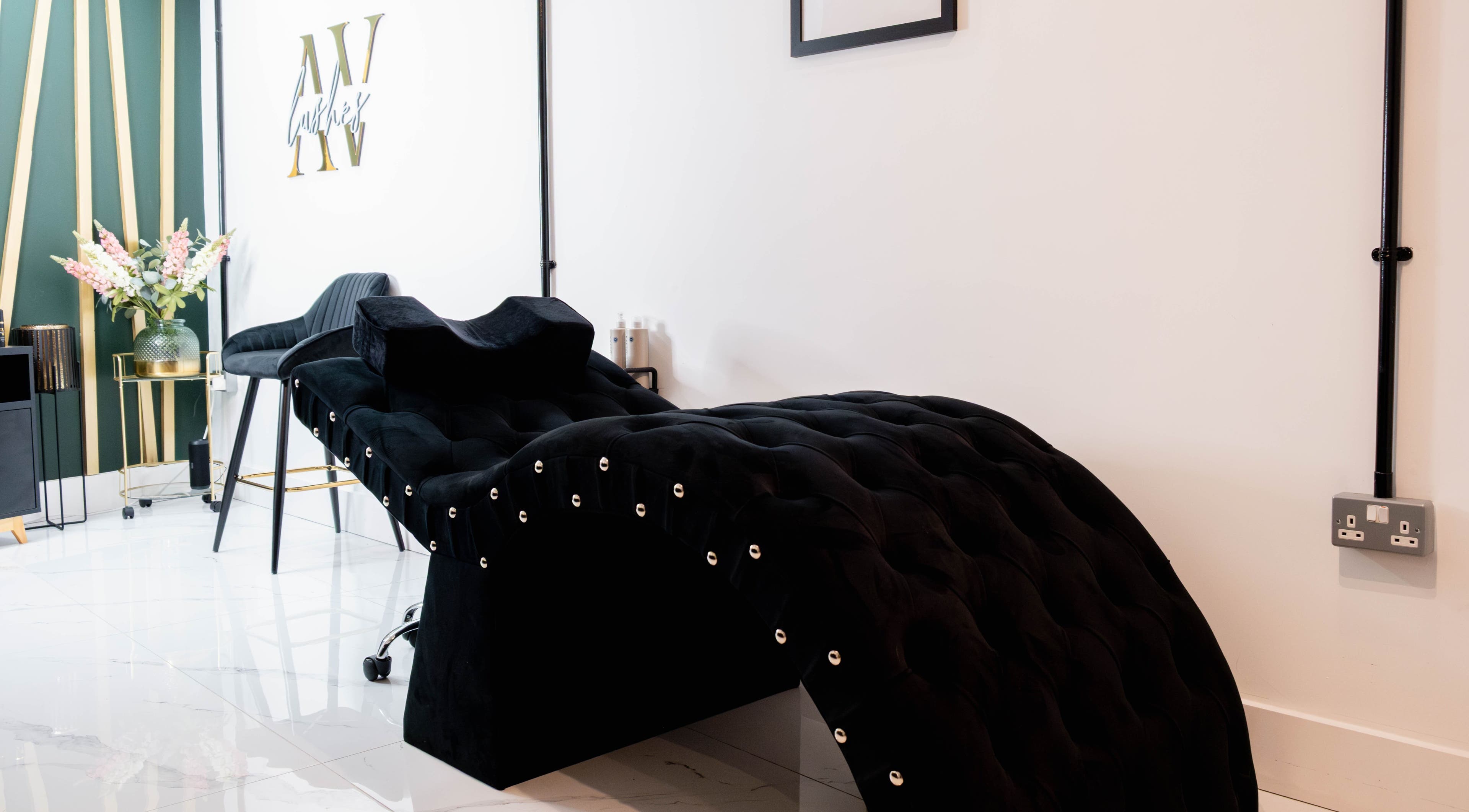 Luxurious lounge at AV Lashes London, London, England, GB with plush decor and sleek black styling chair.