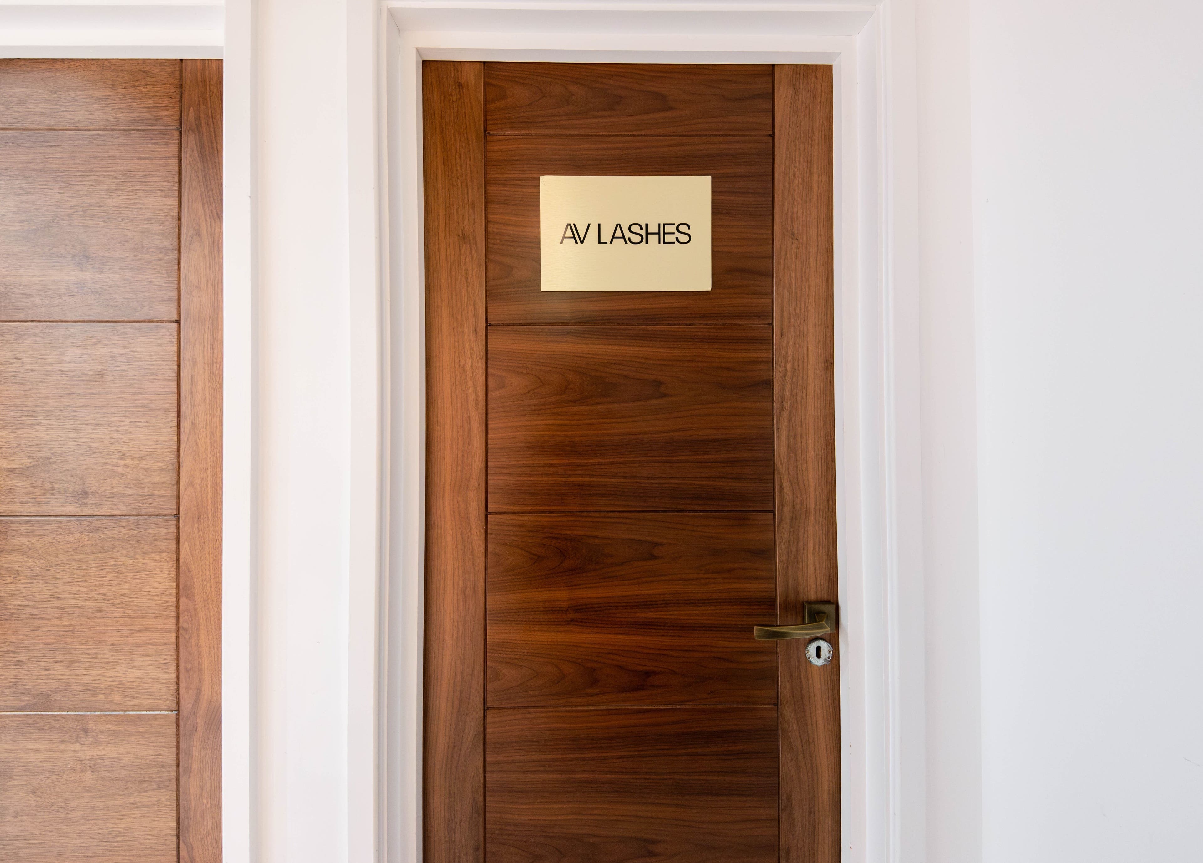 Entrance door of AV Lashes London in London, England, GB with a polished wood finish.