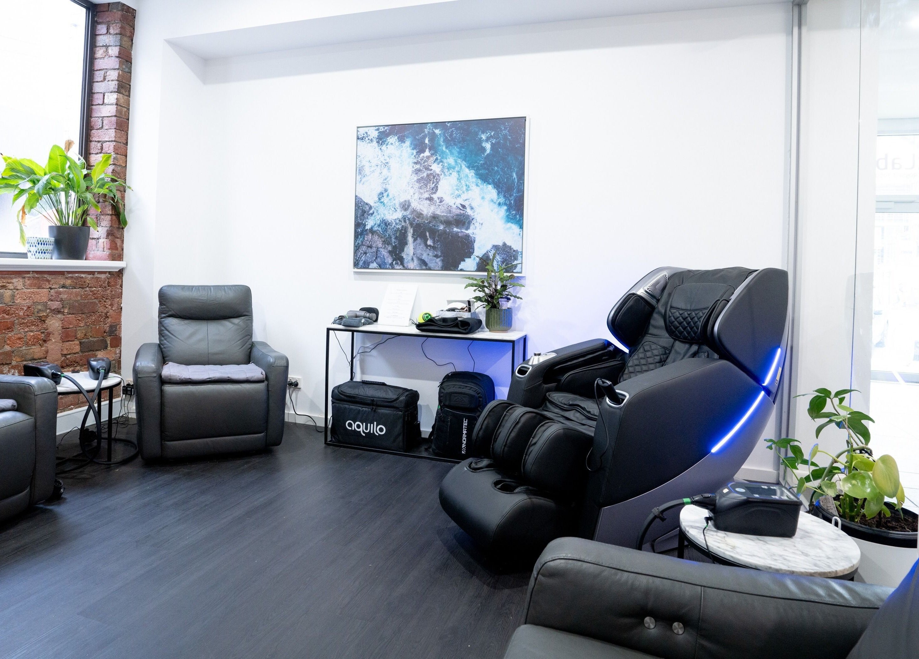 Comfortable massage chairs at Gentle Recovery, South Melbourne, VIC, AU, with modern decor and brick walls.