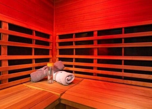 Relaxing wooden sauna at Gentle Recovery, South Melbourne, VIC, AU with towels and a water bottle.