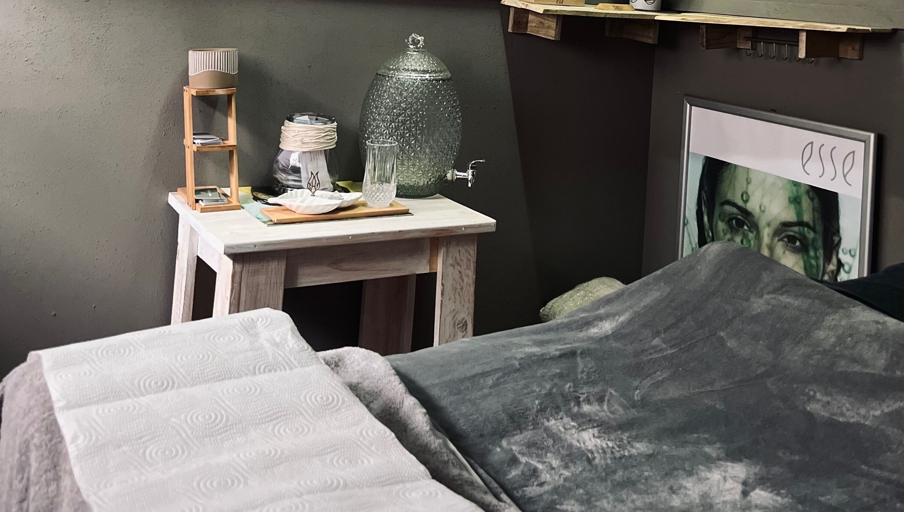 Relaxing spa room at AfriU Refinery in George, Western Cape, ZA featuring cozy blanket and water dispenser.