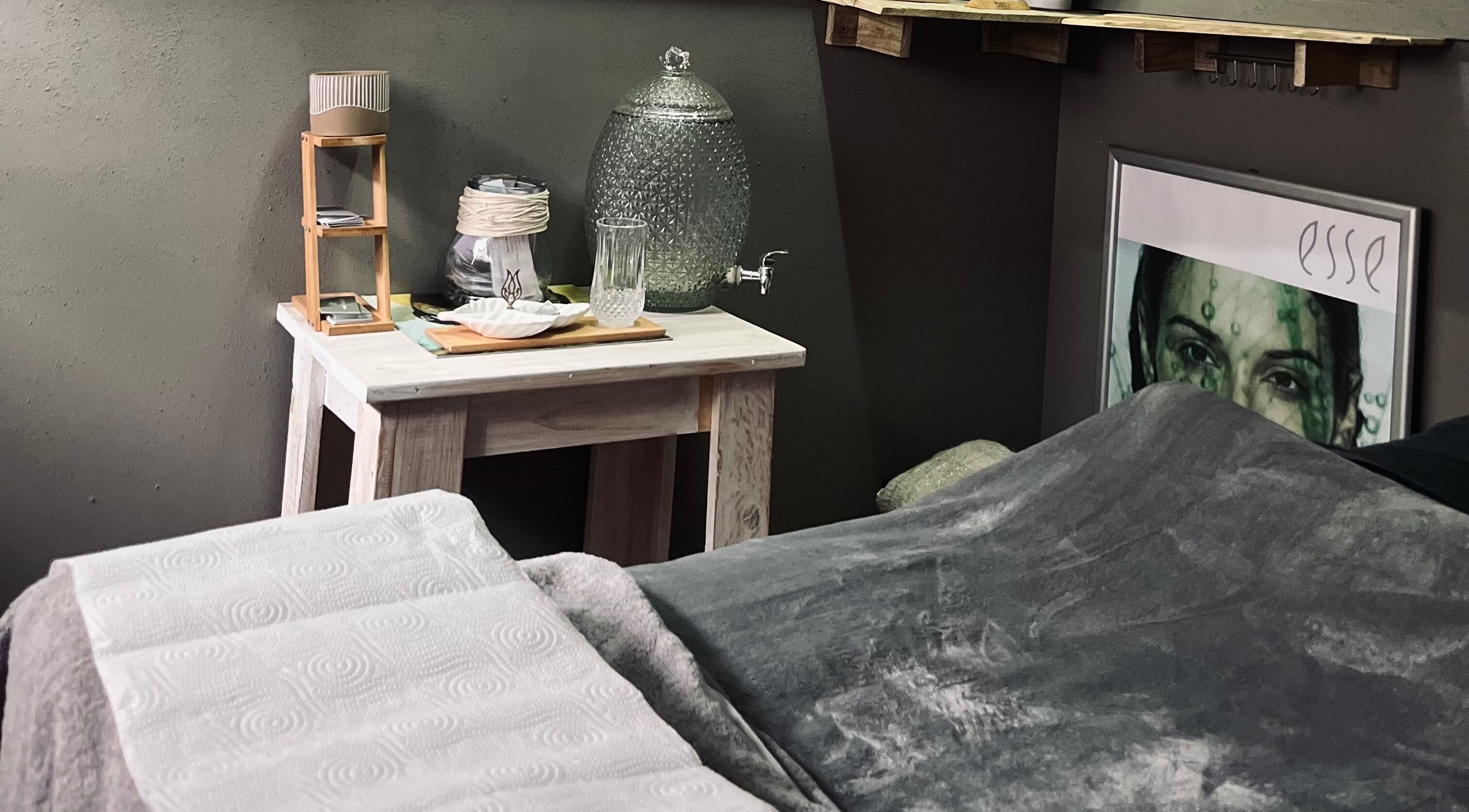 Relaxing spa room at AfriU Refinery in George, Western Cape, ZA featuring cozy blanket and water dispenser.