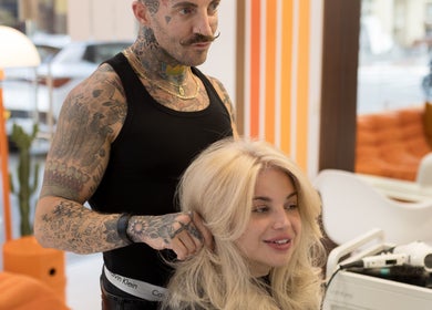 Stylist at Nathan Jeffrey Colorist in Tel Aviv-yafo perfecting a blonde hairstyle with care.