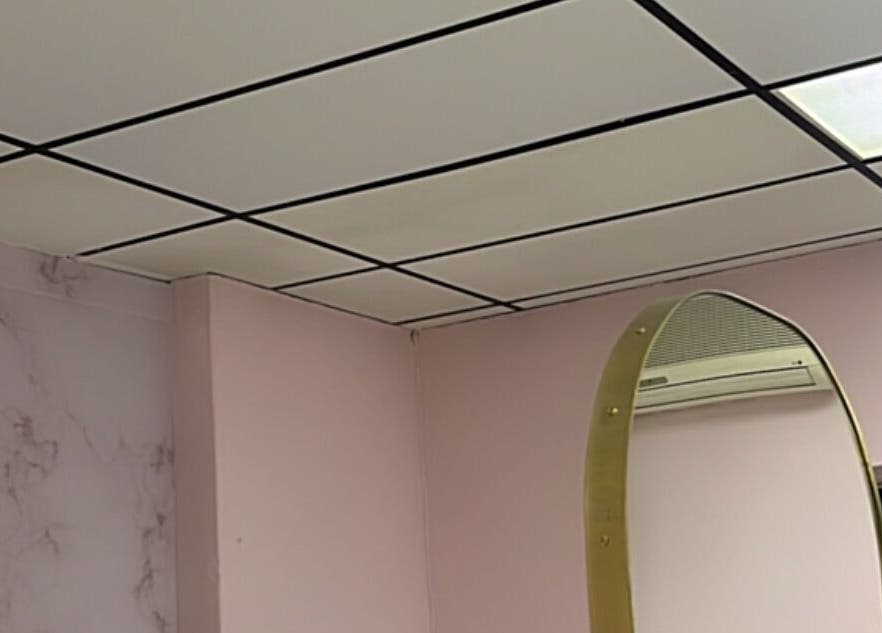 Interior of Melanin Lash Bar SA in Sandton, Gauteng, ZA with pink walls and a unique mirror.