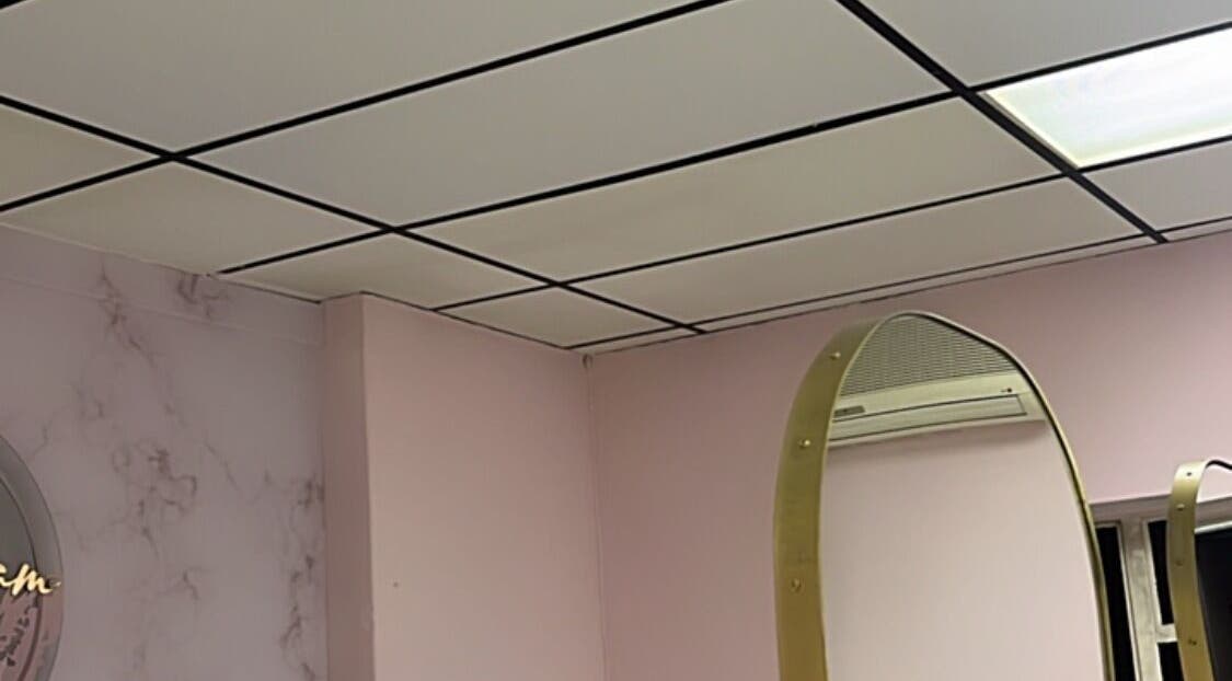 Interior of Melanin Lash Bar SA in Sandton, Gauteng, ZA with pink walls and a unique mirror.