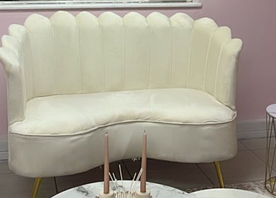 Chic white sofa at Melanin Lash Bar SA in Sandton, Gauteng, ZA, offering a relaxing ambiance.