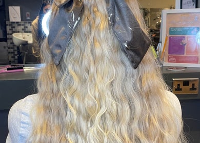 Back view of elegantly styled wavy blonde hair with a bow at MKM.hair, Perth, Scotland, GB.