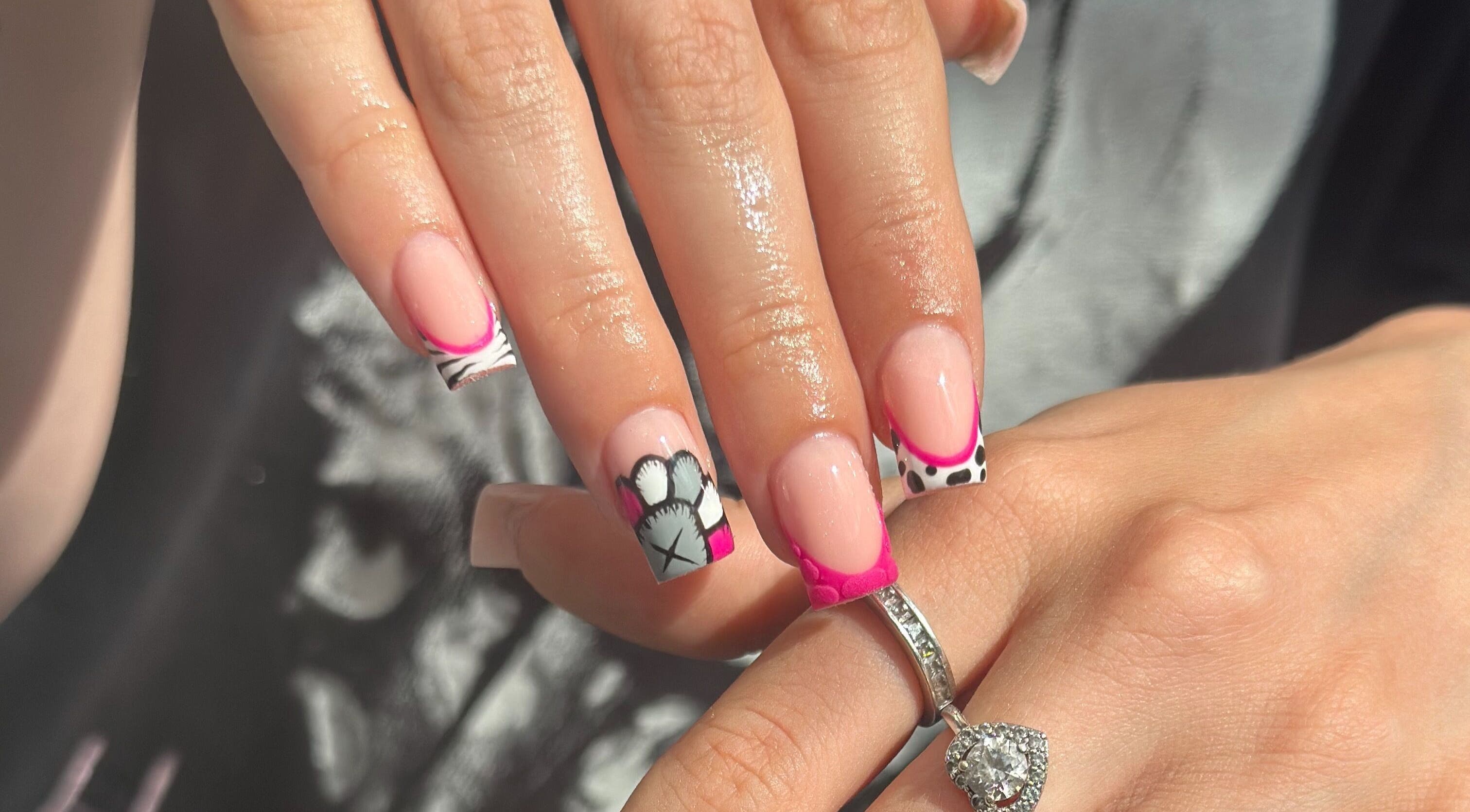 Elegant nail art with pink tips and black designs at Venus Studios, Kirkby In Ashfield, England, GB.