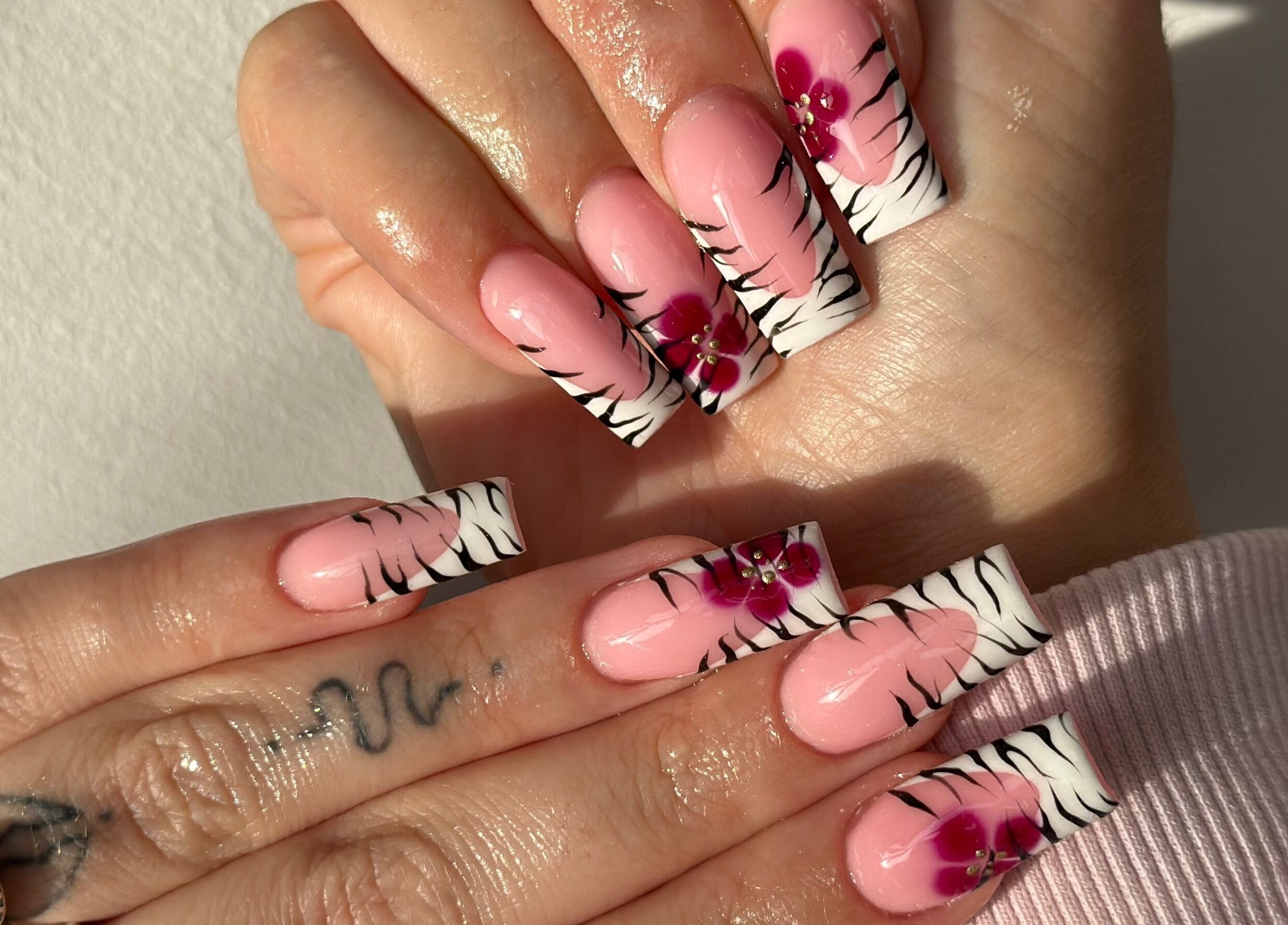 Pink nails with zebra stripes and floral art by Venus Studios, Kirkby In Ashfield, England, GB.