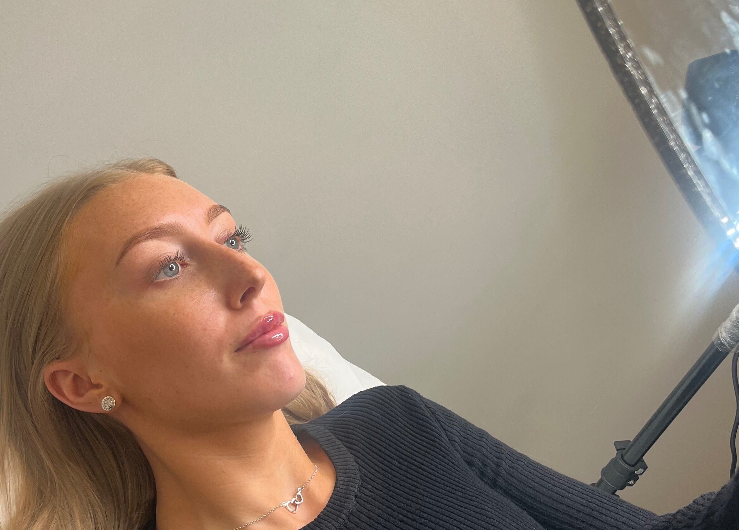 Client admiring results in a mirror at Farr Beyond Aesthetics, Plymouth, England, GB.