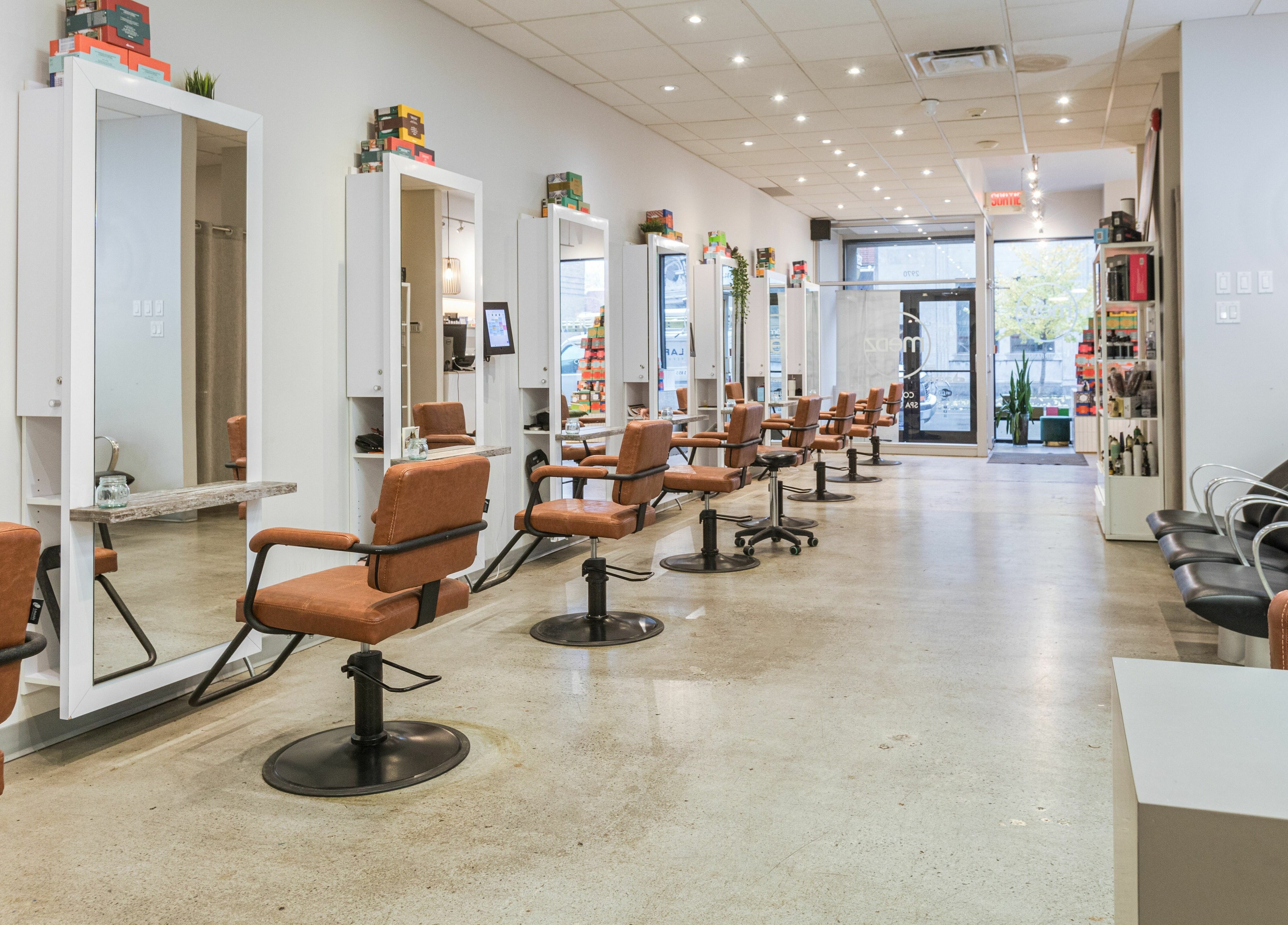 Intérieur moderne de Mëdz Salon Masson à Montréal, Québec, CA avec des fauteuils et miroirs élégants.