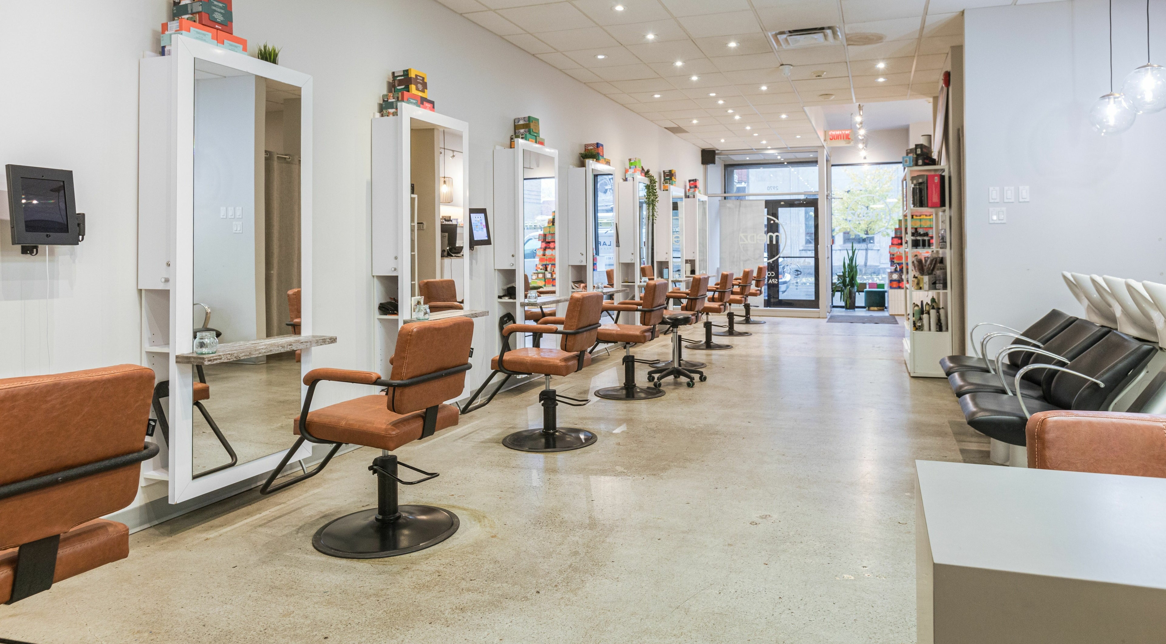 Intérieur moderne de Mëdz Salon Masson à Montréal, Québec, CA avec des fauteuils et miroirs élégants.