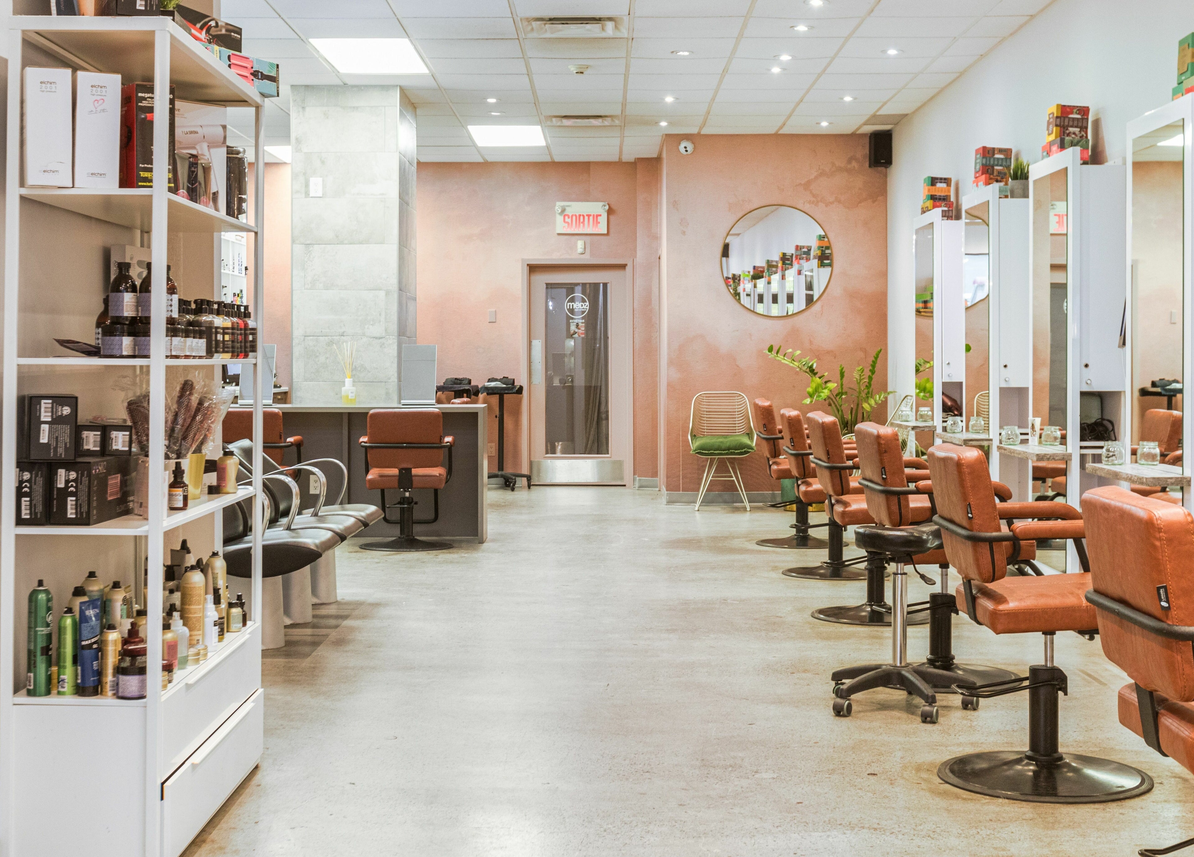 Intérieur stylé de Mëdz Salon Masson à Montréal, Québec, CA, avec chaises contemporaines et produits capillaires.