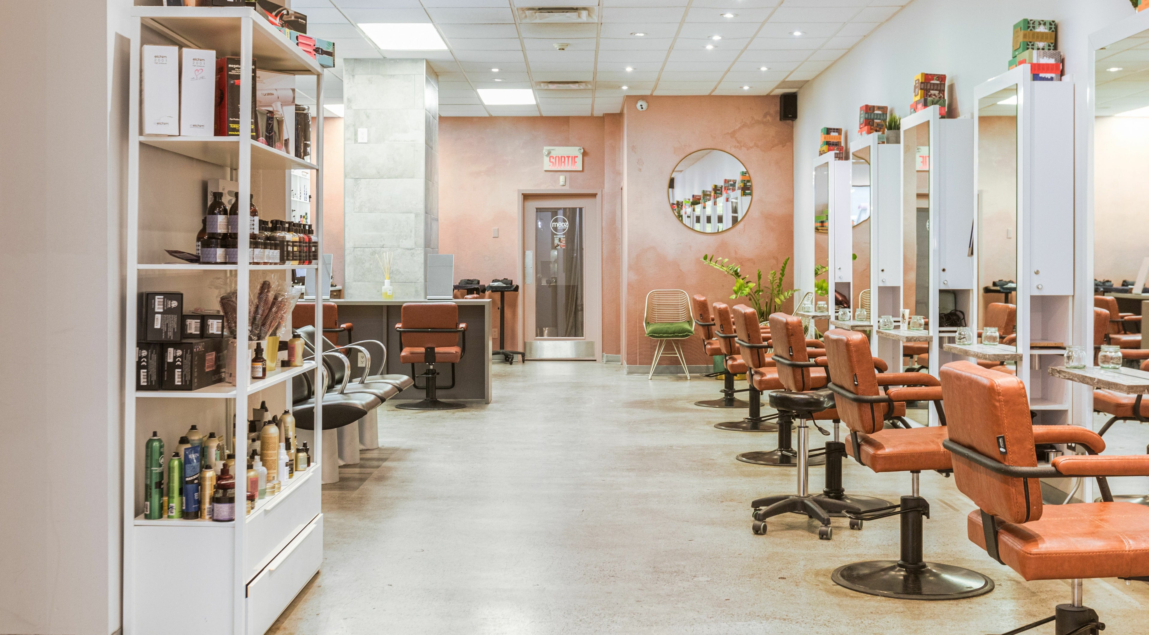 Intérieur stylé de Mëdz Salon Masson à Montréal, Québec, CA, avec chaises contemporaines et produits capillaires.
