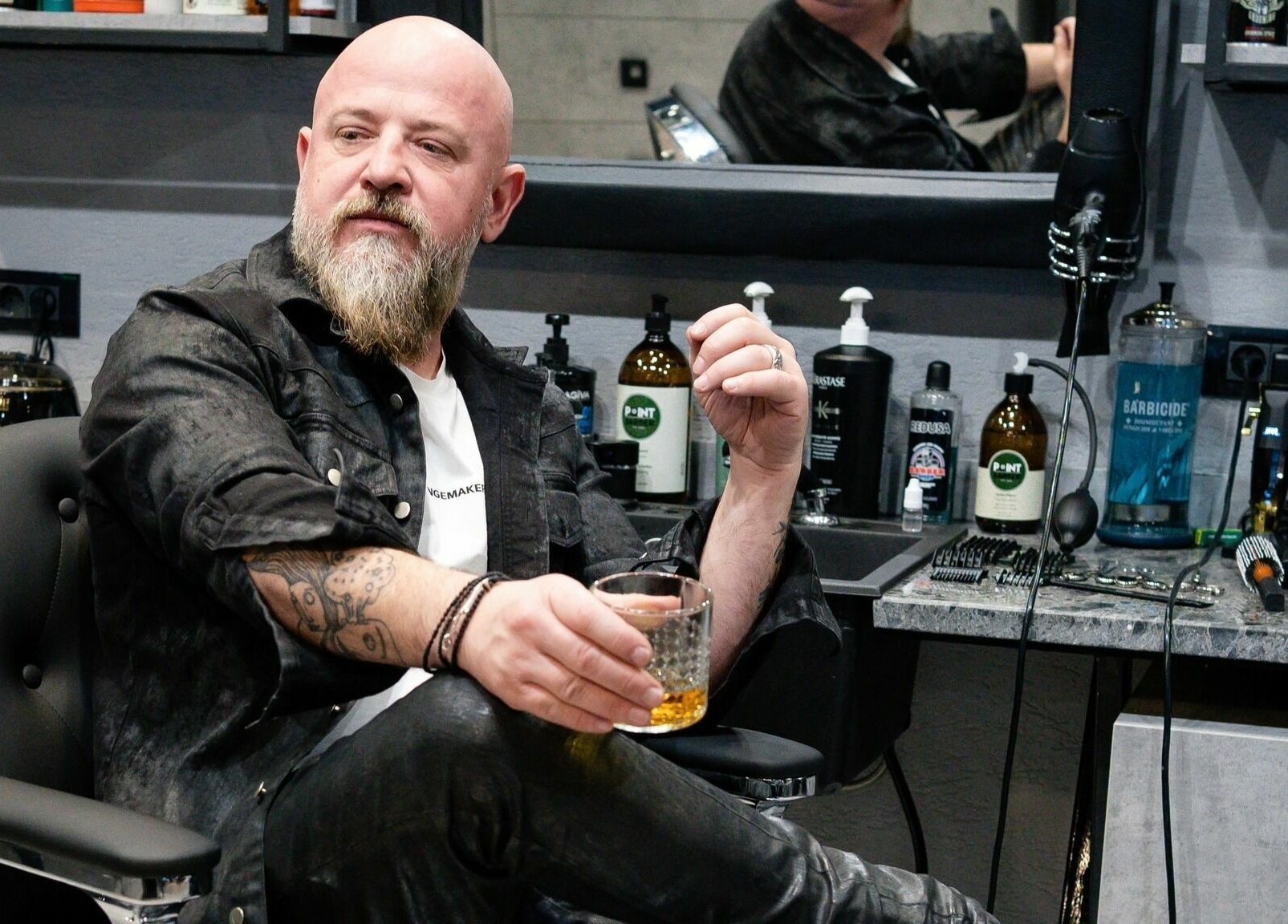 Maestru bărbier savurând un pahar la The Premium Barbers Dorobanti, București, București, RO.